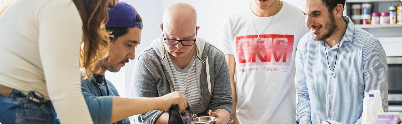Reena nonprofit participants collaborating in a kitchen activity, supported by inclusive programs and efficient purchasing with Procurify